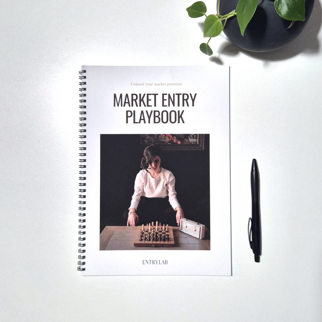 Image of Entrylab Market Entry Playbook laying on a desk with pen and plant next to it.
