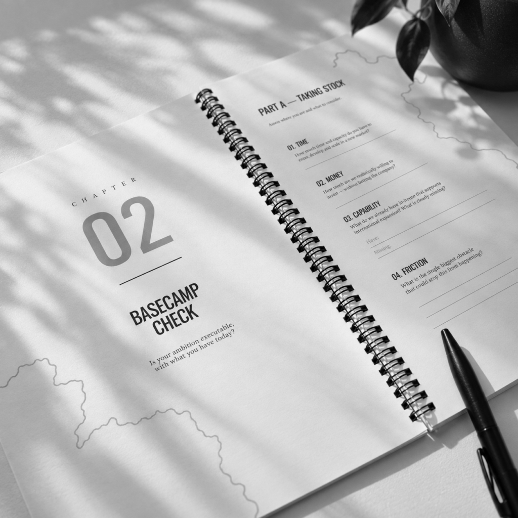 Entrylab Market Entry Playbook laying on a desk next to a plant and a pen on a black and white image.