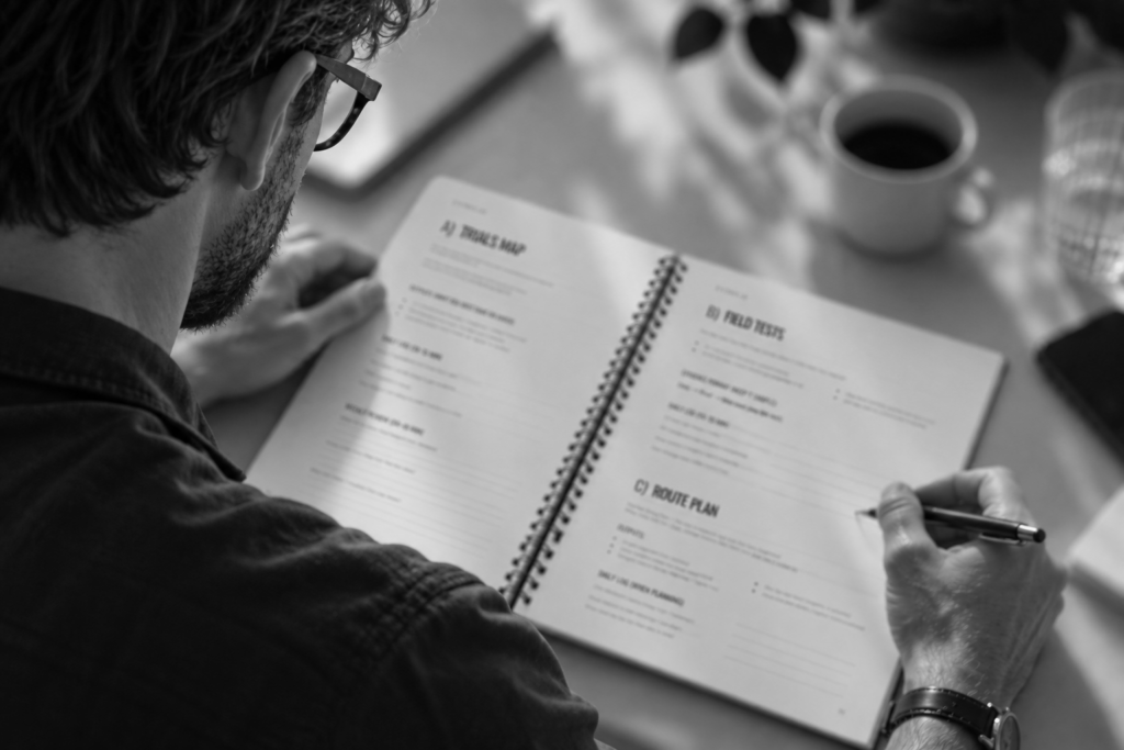 A black and white image of a male working with market entry playbook.